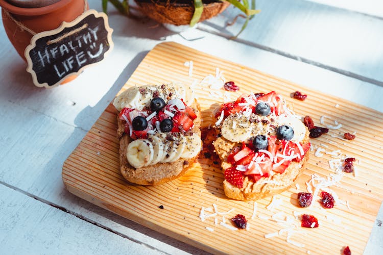 Toast With Fruit Toppings On A Wooden Chopping Board