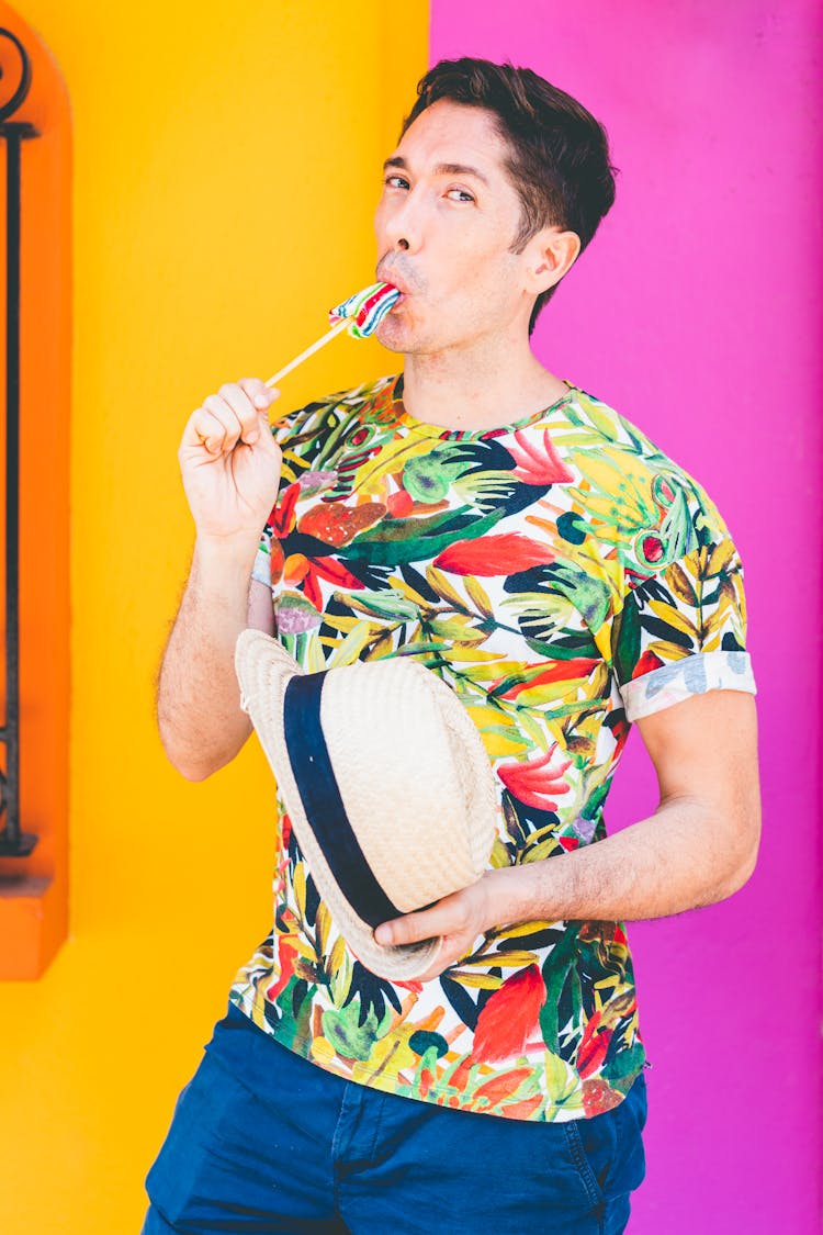 A Man In Floral Shirt Holding A Lollipop