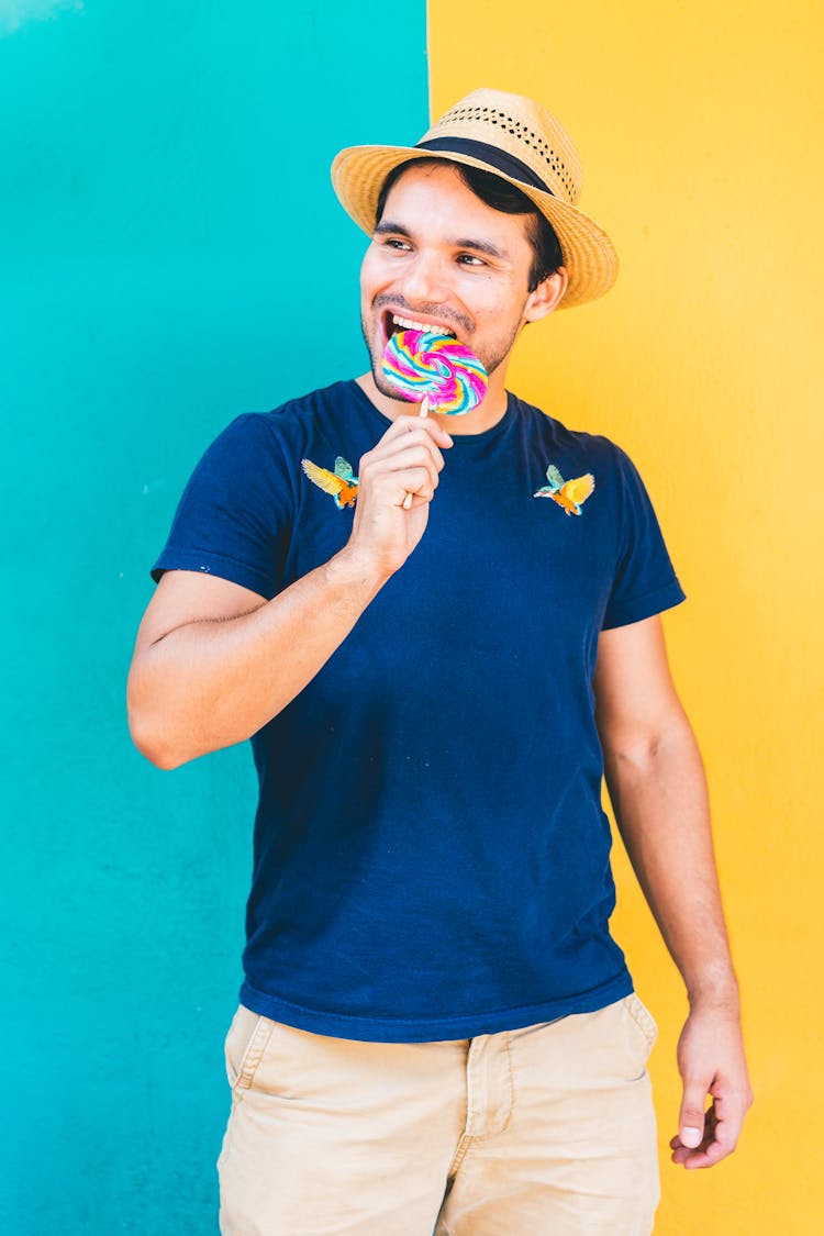 A Man In Blue Shirt Holding A Lollipop