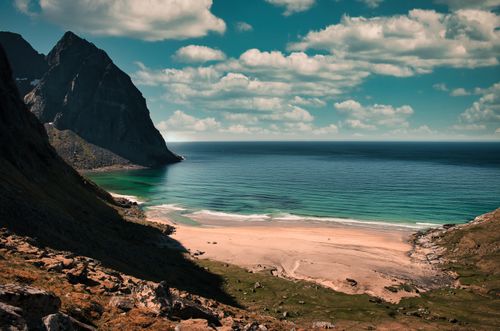 Free Explore Moskenes, Nordland with its stunning beach and dramatic mountains under a bright summer sky. Stock Photo