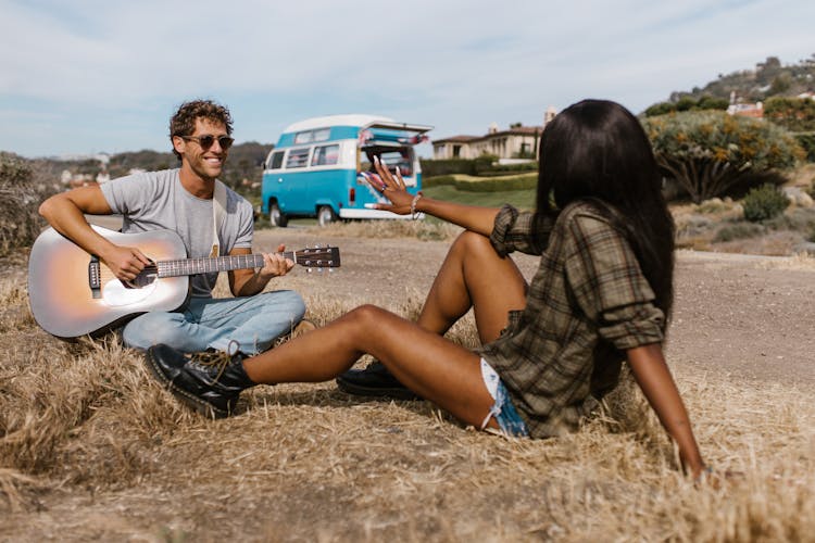 A Man Playing Guitar On The Field