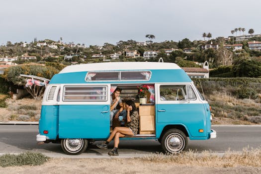 Couple enjoys a scenic road trip in a vintage campervan by the coast, embracing nature and adventure.