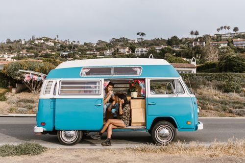 Free Couple enjoys a scenic road trip in a vintage campervan by the coast, embracing nature and adventure. Stock Photo