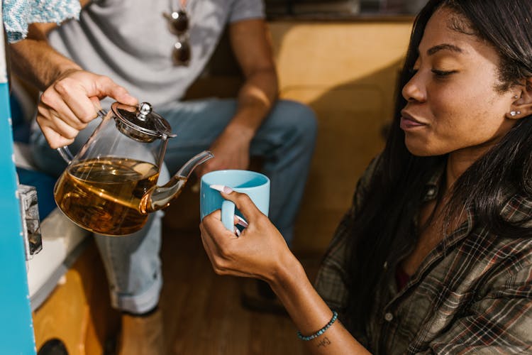 A Woman In Plaid Long Sleeves Holding A Cup Of Drink