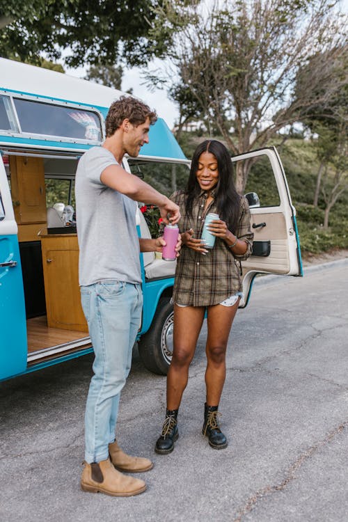 Man and Woman Standing Beside the Blue Campervan