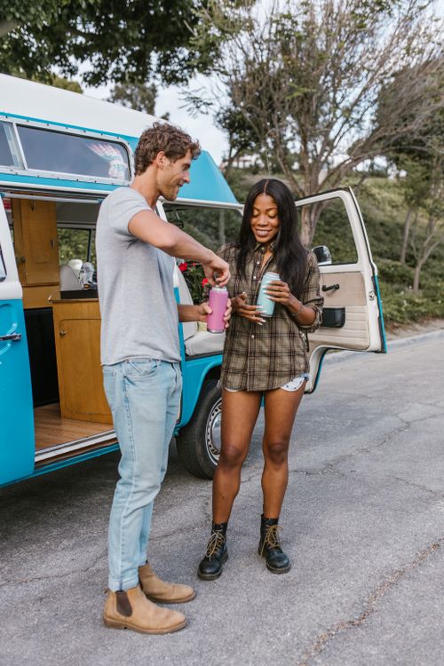 Free Happy interracial couple using a vintage campervan during a summer road trip. Stock Photo