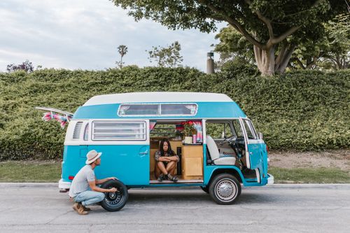 Free A couple enjoying a road trip with their vintage campervan, capturing a moment of rest and adventure. Stock Photo
