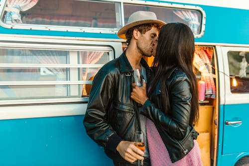 Photograph of a Couple in Leather Jackets Kissing