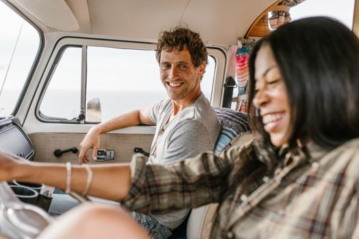 Smiling couple enjoying a road trip adventure inside a vintage campervan.