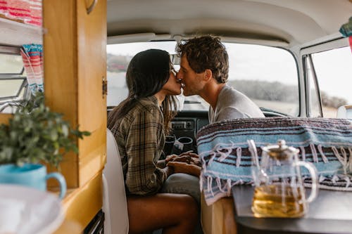 A Couple Kissing Inside the Camper Van 