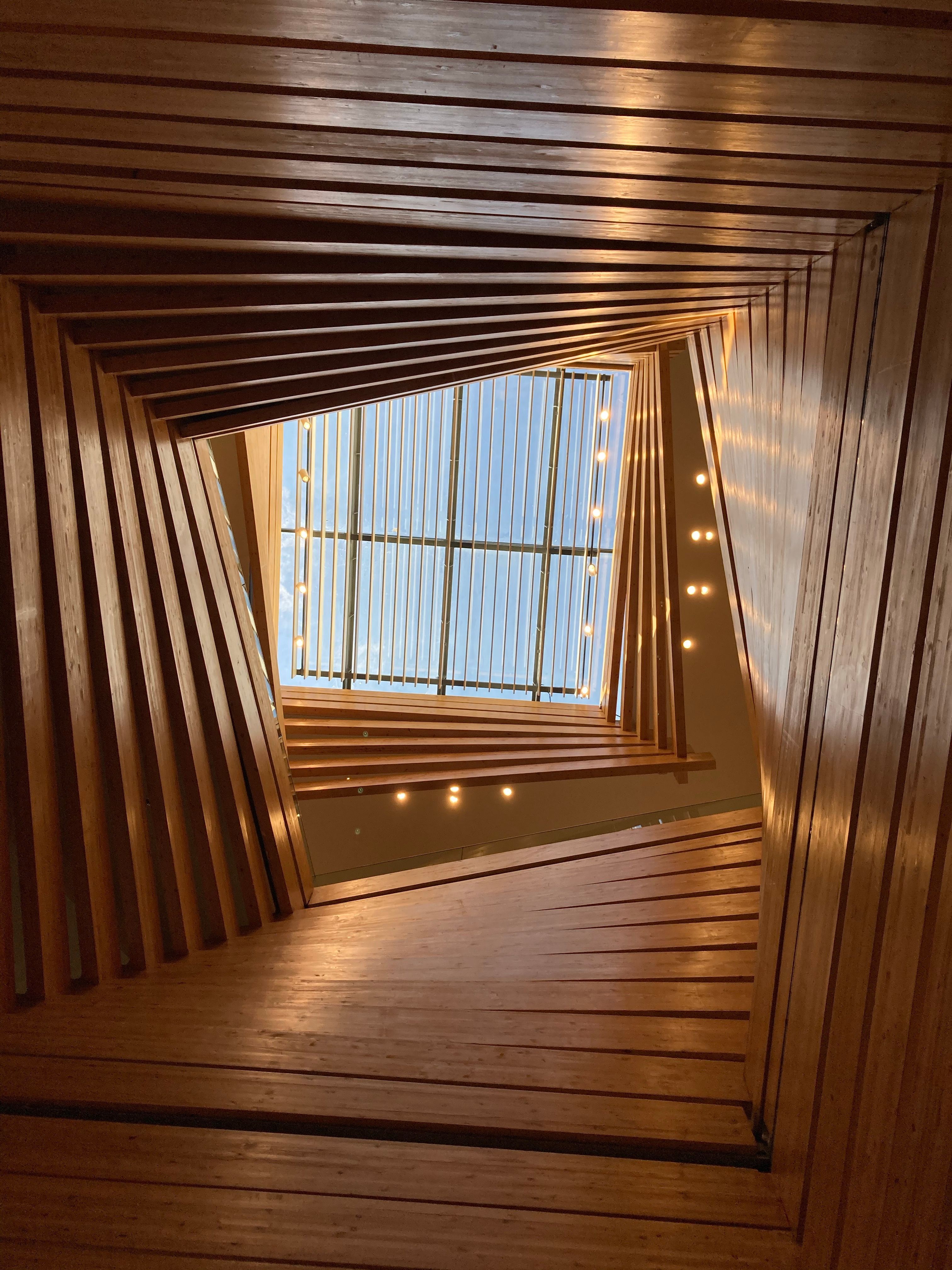 A dramatic multi-storey atrium with timber slats wrapping all walls