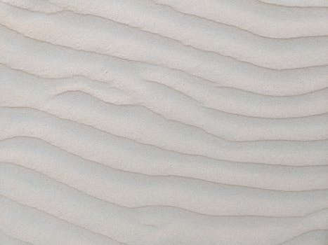 Close-up of rippled sand texture at Varca Beach, Goa, India, showcasing natural patterns.