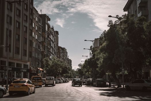 A bustling street scene in Gaziantep, Turkey showcasing urban architecture and vehicles on a sunny day.