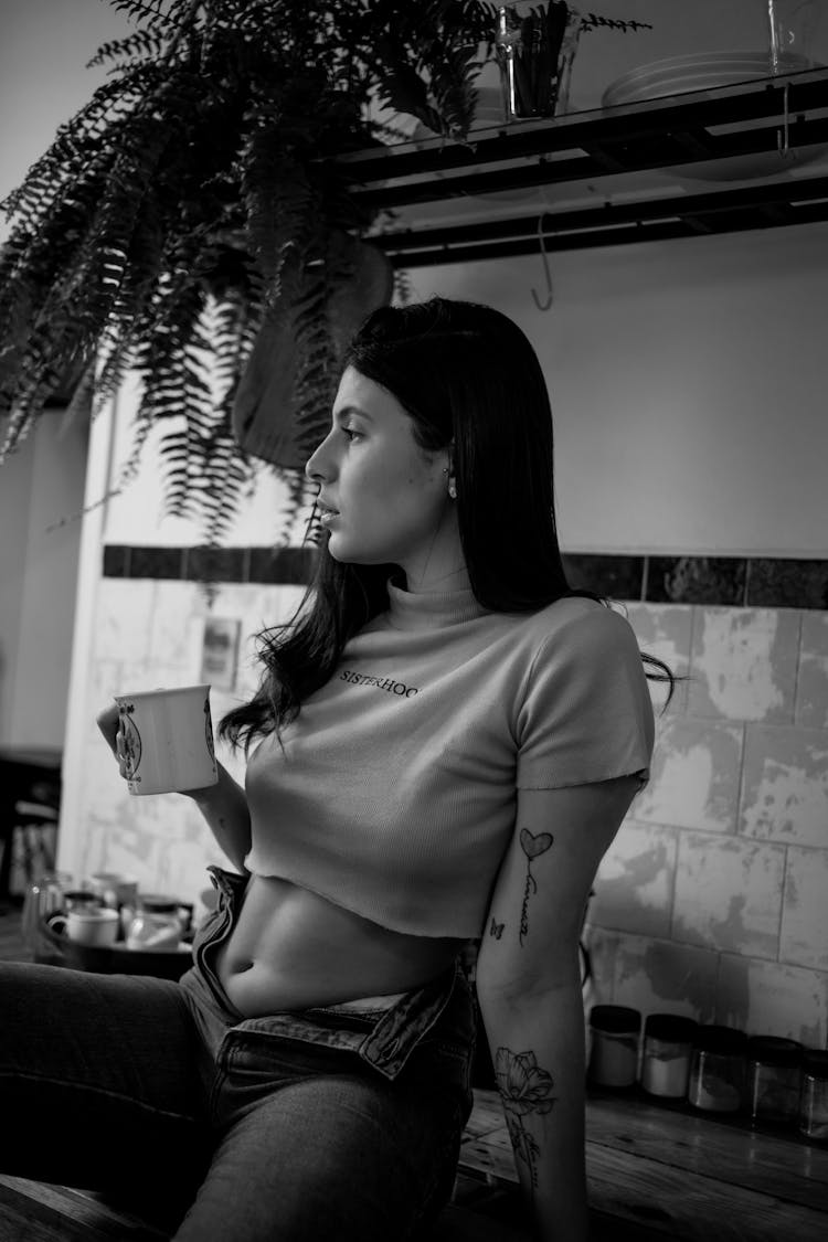 Portrait Of Woman Drinking Coffee In Kitchen