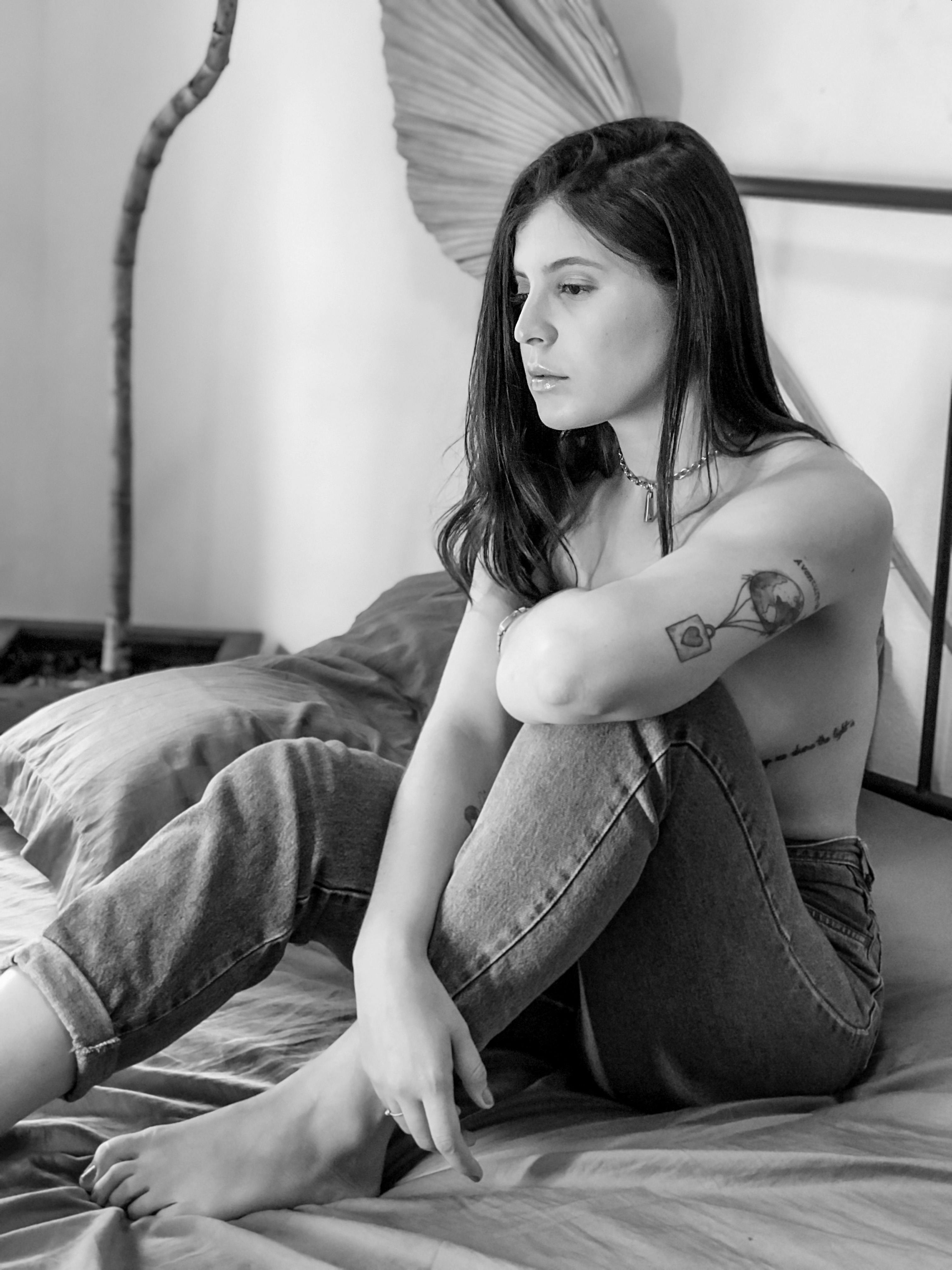 Free Woman Seated on Bed Topless Stock Photo