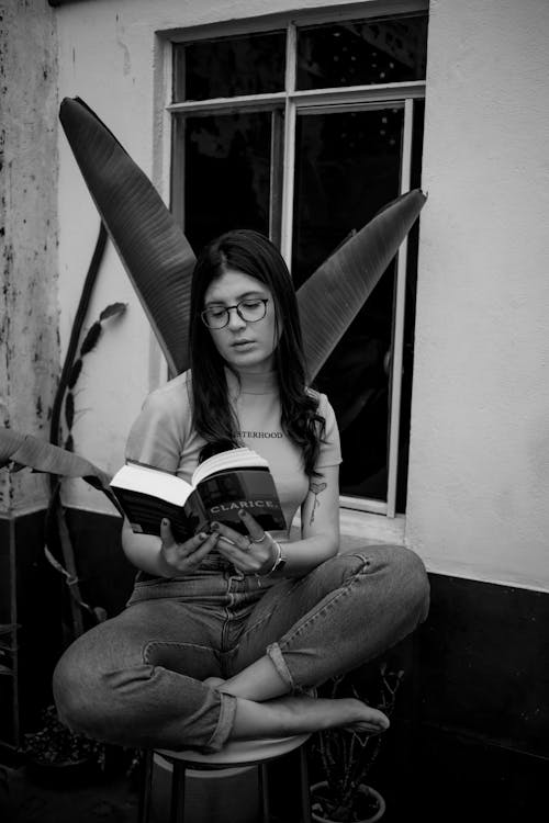 Woman Wearing Black Framed Eyeglasses Reading a Book