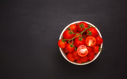Free Red Cherry Tomatoes in the White Bowl on the Black Surface Stock Photo