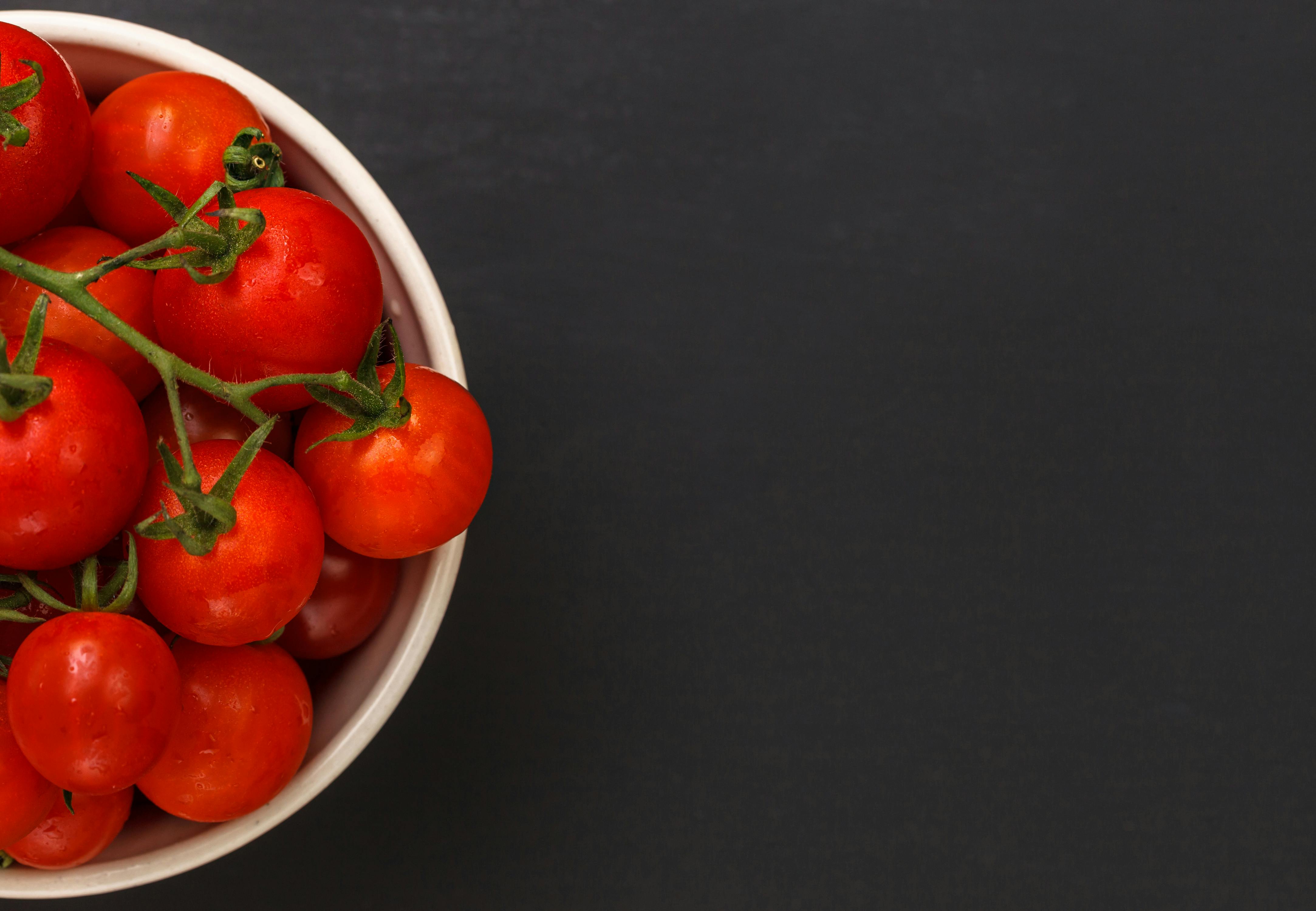 Close-up of ripe red tomatoes in a bowl providing ample copy space for text.