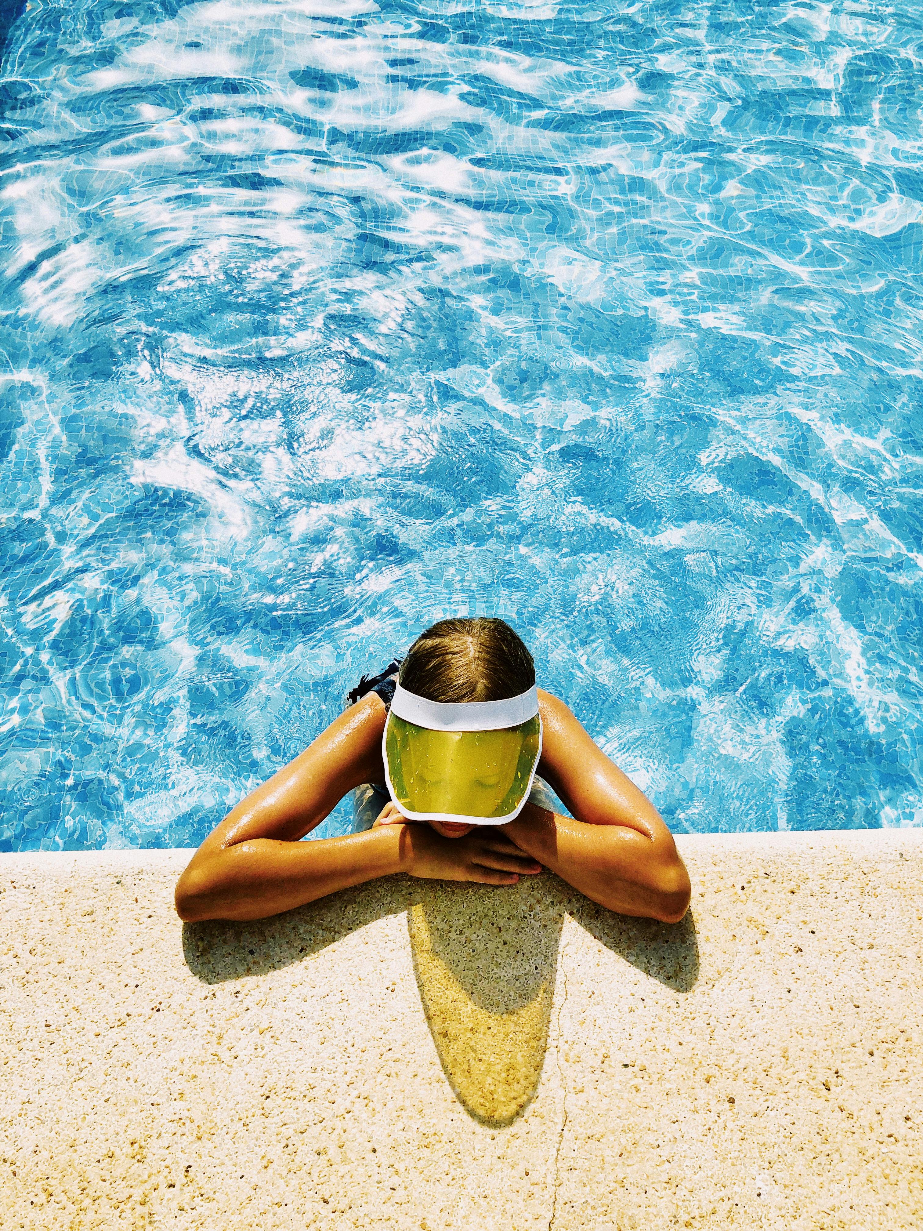 person resting on the side of a swimming pool