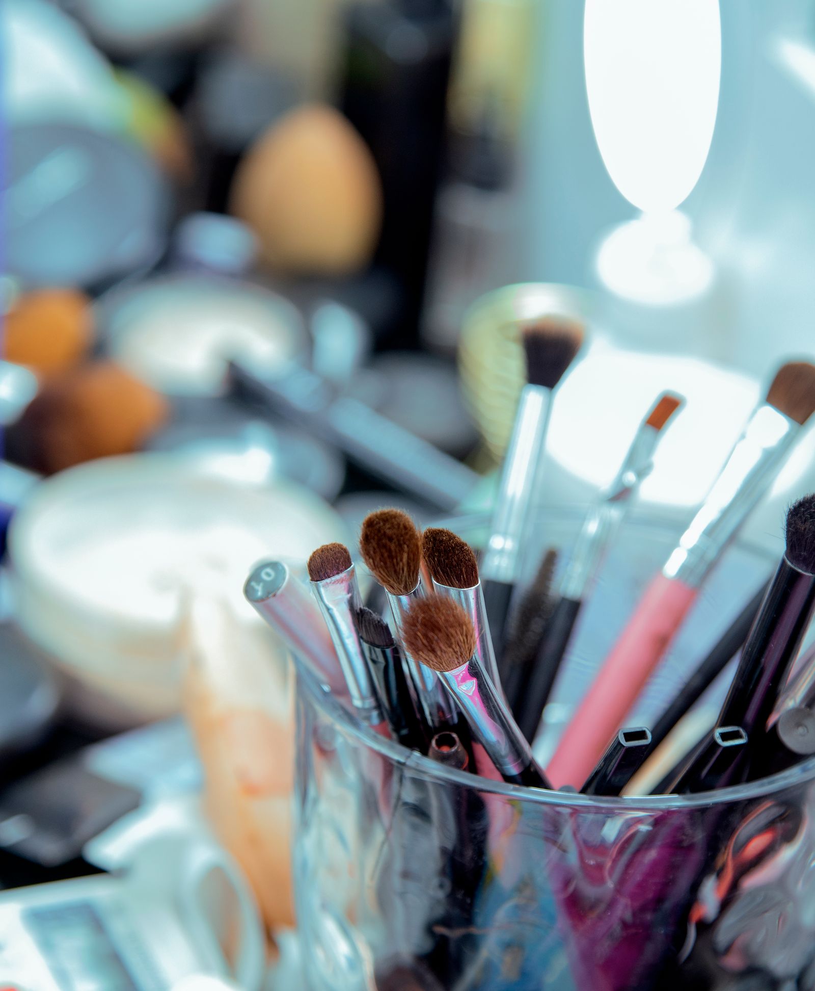 Clean makeup brushes arranged in a glass holder on an elegant vanity table