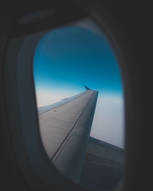 Free A scenic view of the sky and airplane wing from a passenger window providing a flight experience. Stock Photo