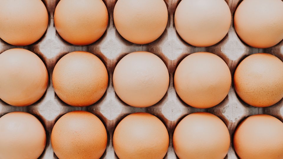 Rows of brown eggs in a tray
