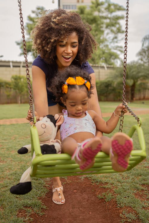 Free Girl in White Tank Top Sitting on Swing Stock Photo