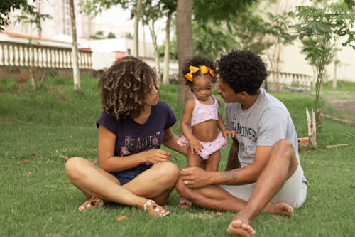 Black family spending weekend on meadow in urban park