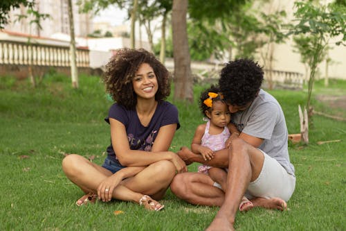Free Young Couple with Their Daughter Sitting at the Park Stock Photo