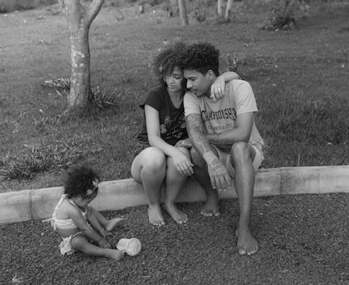 Grayscale Photo of a Family Sitting at the Park