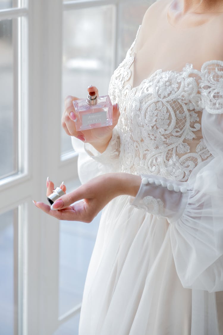 Woman In White Dress Holding A Perfume Bottle