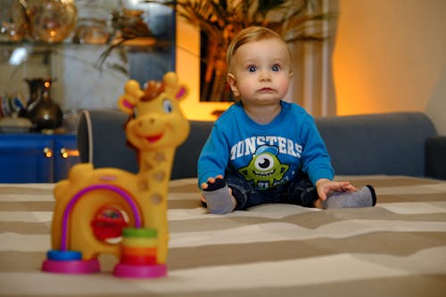 Baby Boy Sitting on a Bed