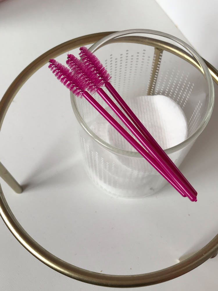 Pink Mascara Brushes On A Glass With Cotton Pads