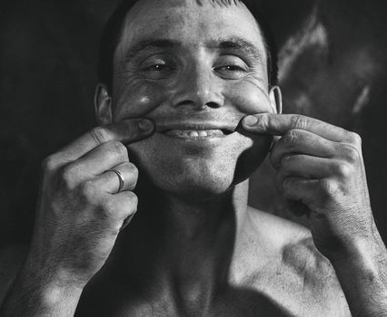 Monochrome Photo of a Man Pinching His Cheeks