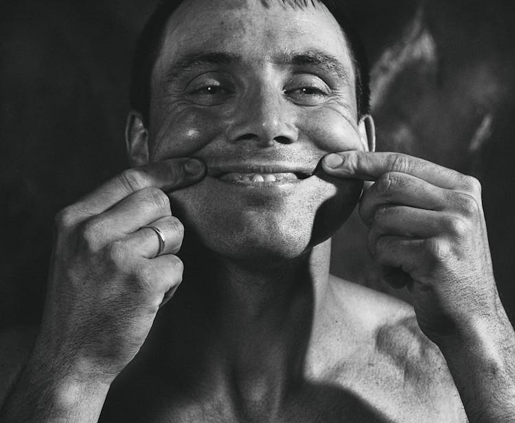 Monochrome Photo Of A Man Pinching His Cheeks