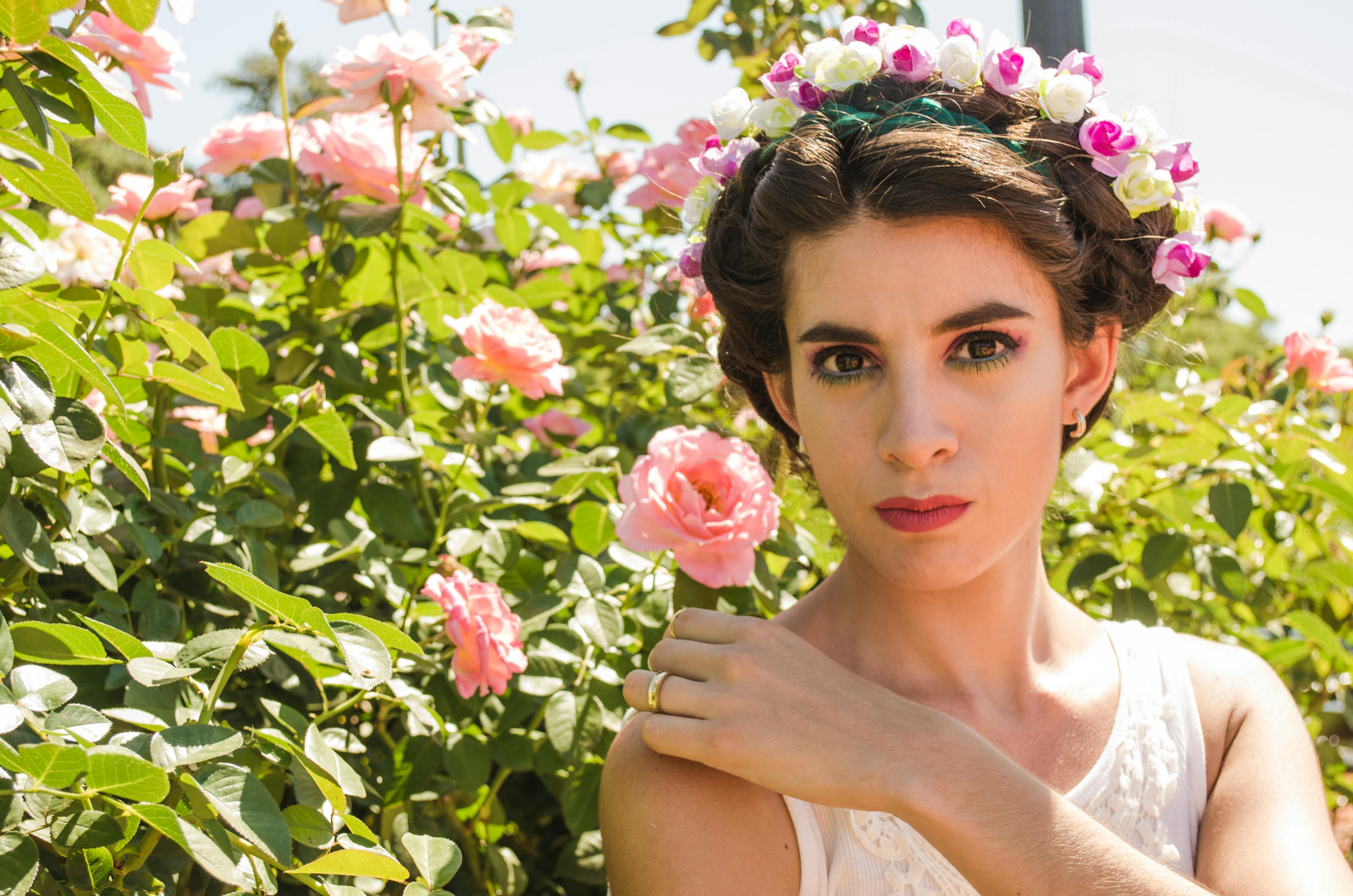 阳光明媚的花园里，玫瑰盛开，一幅戴着花冠的女人的肖像
