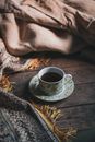 From above of cup of hot tea and saucer placed on wooden floor against carpet pushed back