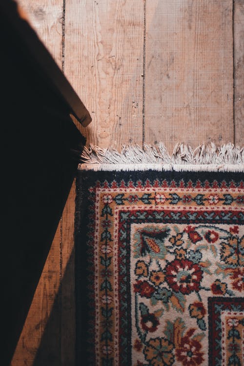 Fragment of rug on old wooden floor