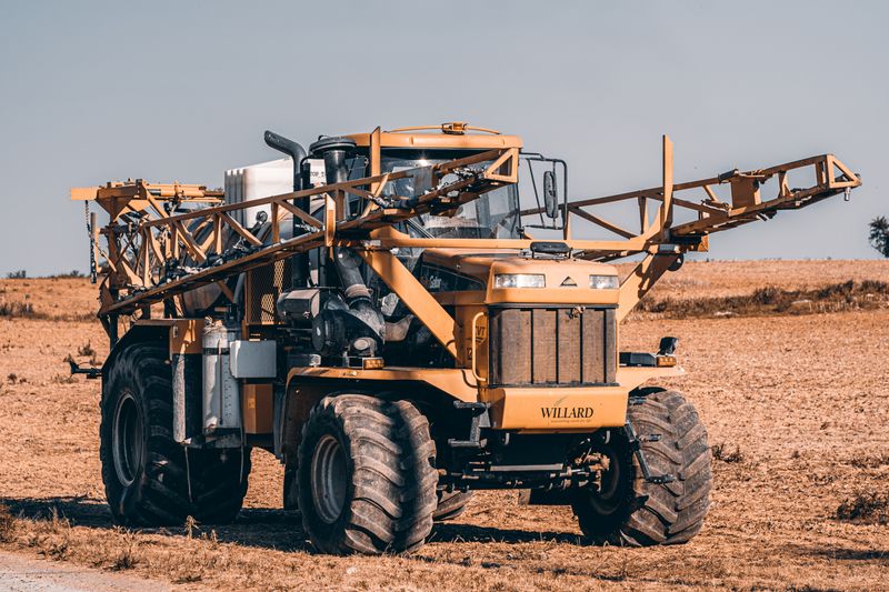 A self-propelled agricultural sprayer in a vast field showcasing modern farming technology