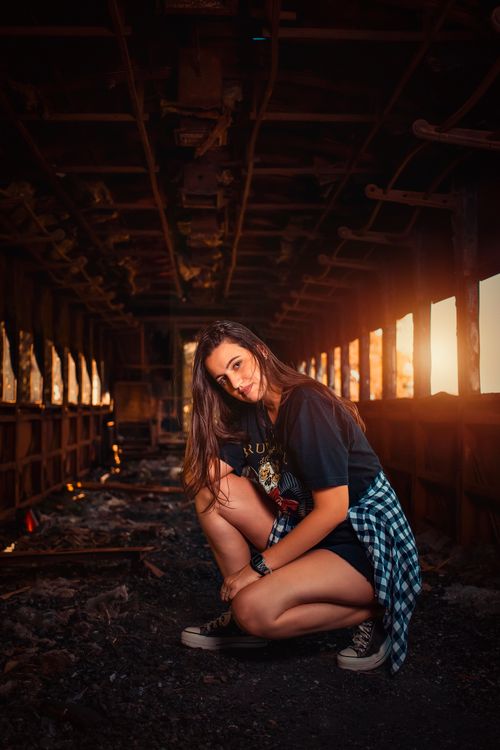 Free Portrait of a woman posing inside an abandoned train car with a moody vibe. Stock Photo