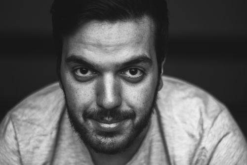 Free Close-up black and white portrait of a young man with facial hair and intense gaze. Stock Photo
