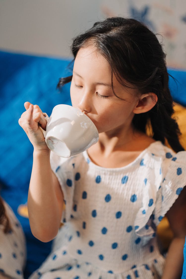 A Girl Drinking On A Cup