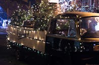 一辆装饰着圣诞灯和树木的老式卡车，在夜晚营造出节日气氛