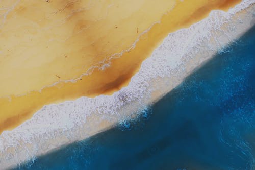 Aerial Shot of Water Waves Crashing on Shore