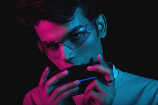 Close-up portrait of a man with sunglasses in vibrant neon lighting.