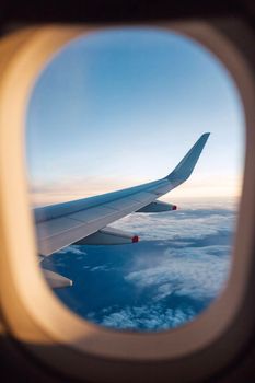 Captivating view of airplane wing and clouds during a sunset flight.