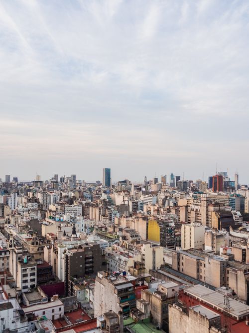Free Aerial view of a bustling city skyline with diverse buildings under a bright sky. Stock Photo