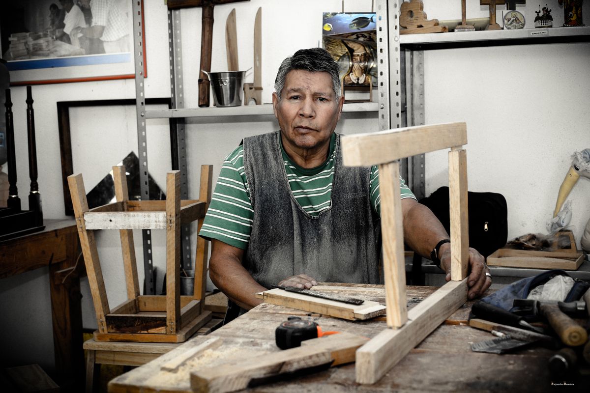 Menuisier assemblant une structure en bois sur son établi