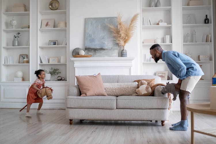 Father And Daughter Playing In The Living Room