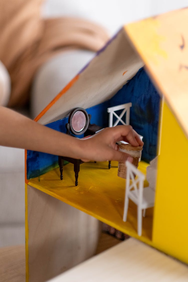 A Kid Playing With A Playhouse